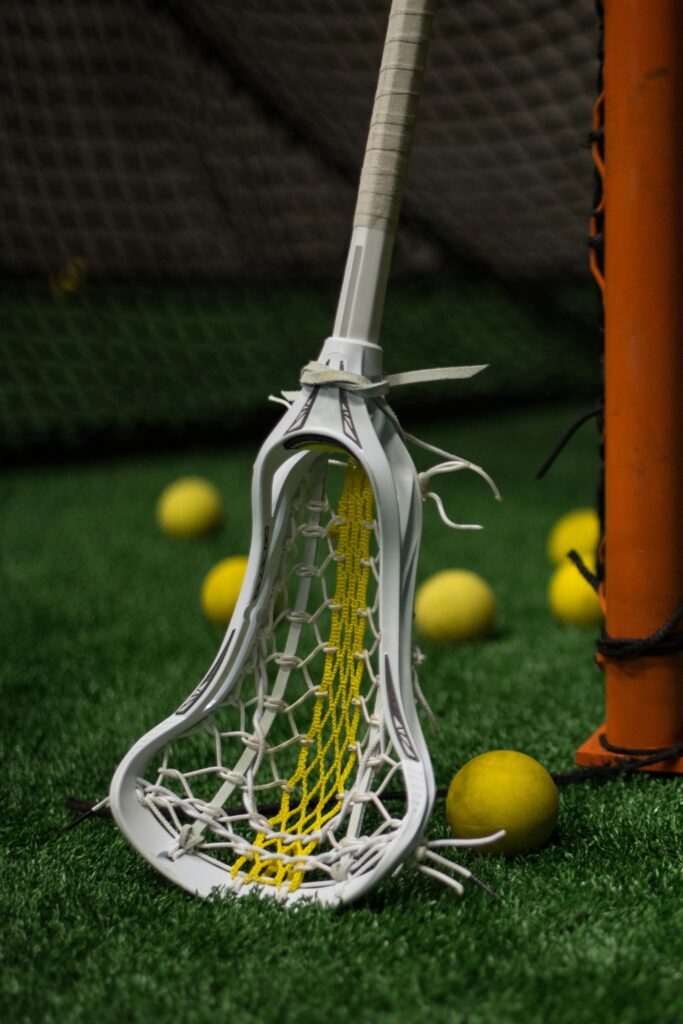 Lacrosse stick and balls on turf during a training or recruiting practice session.