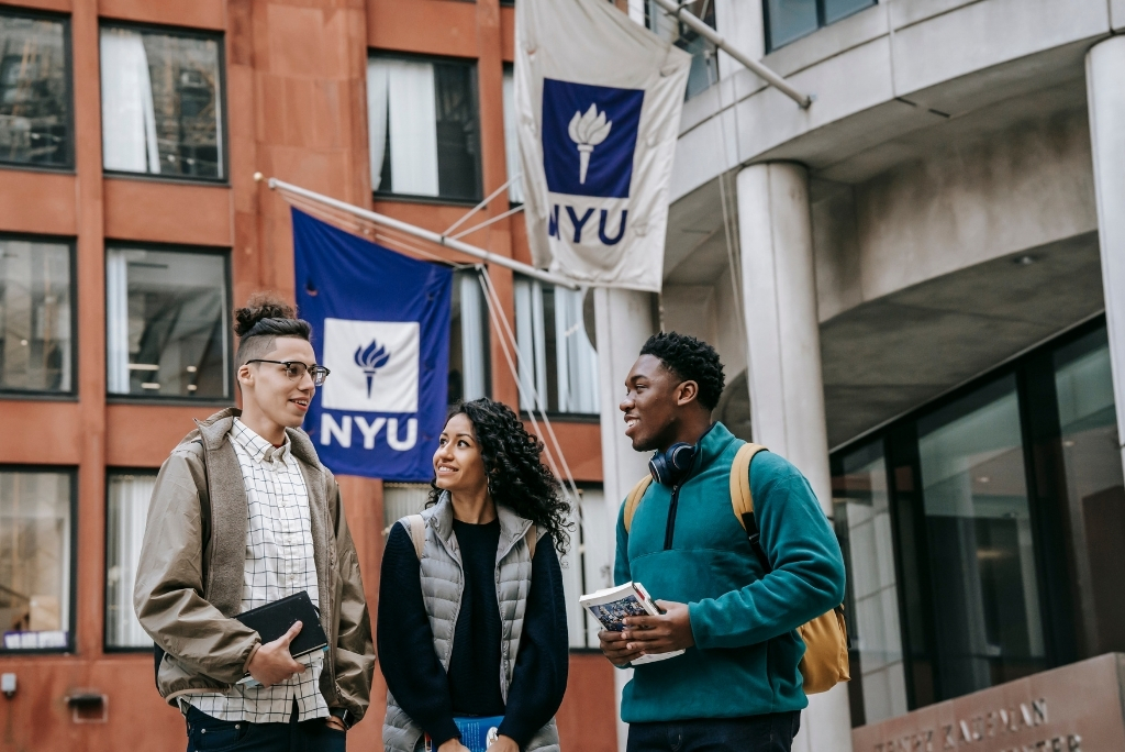 NYU students talking on campus, representing New York University admissions and student life.