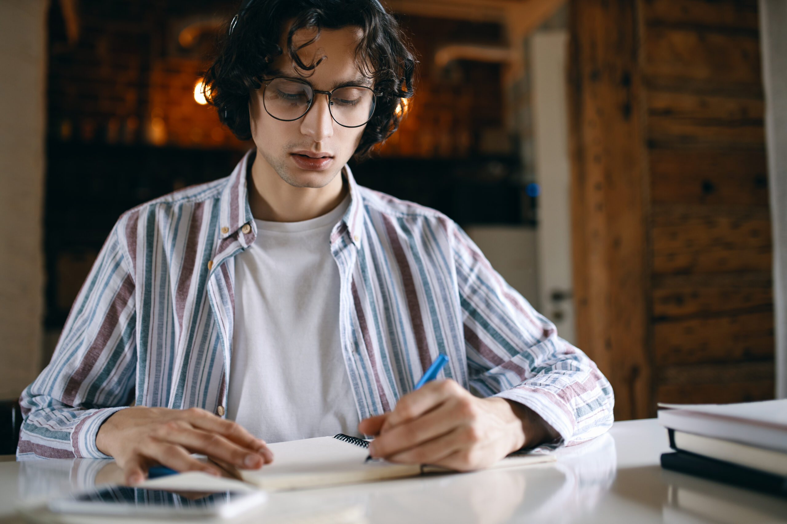 High school student taking notes while planning a pre-law college application strategy.
