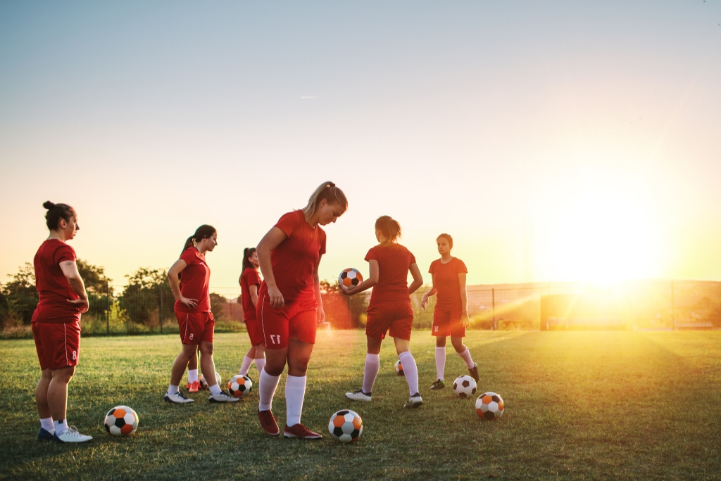 Women’s soccer players training on a field, representing college soccer recruiting.