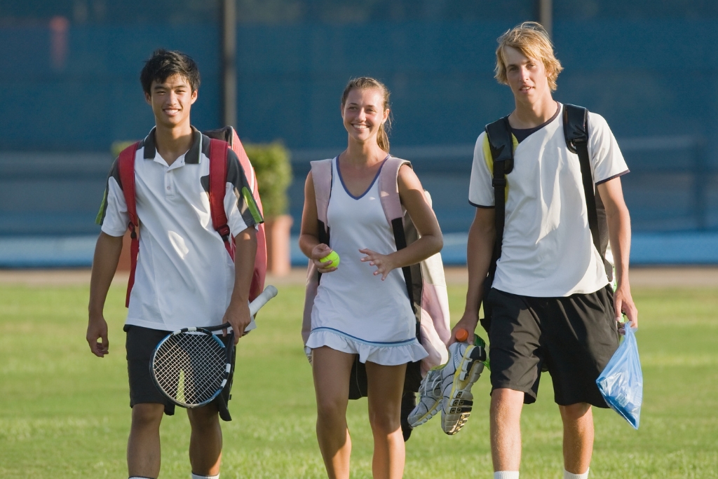 College tennis players carrying rackets and gear, representing tennis ratings used in student-athlete recruiting.