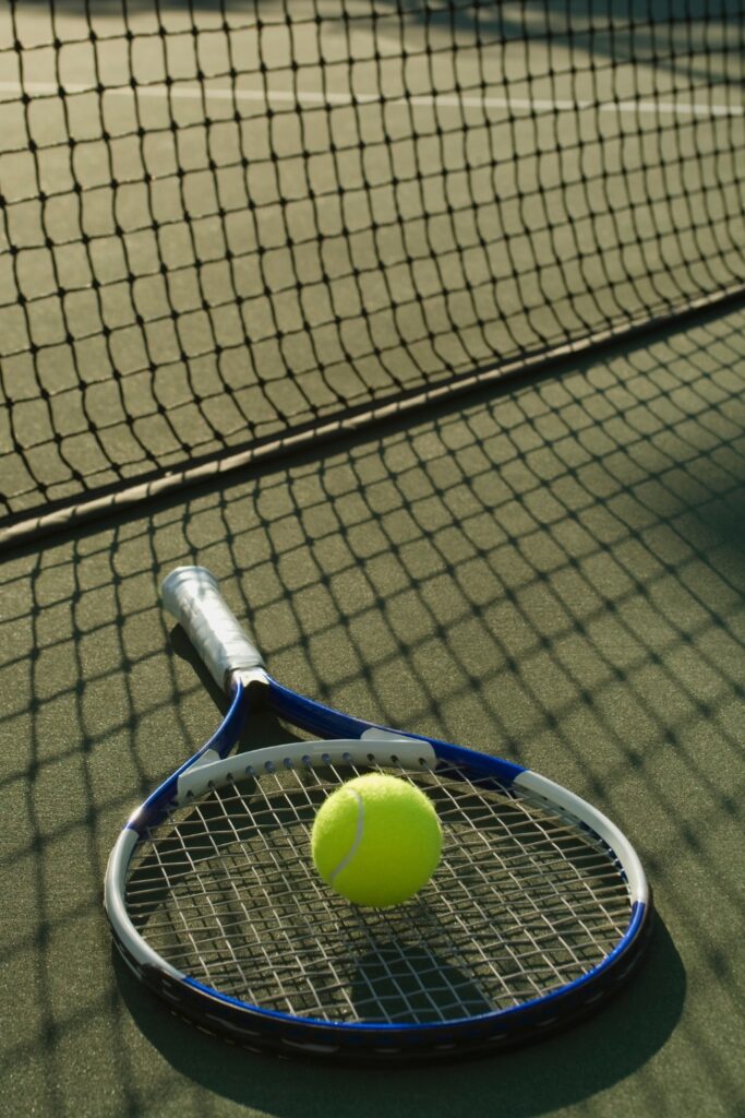 Tennis racket and ball on a court representing college tennis recruiting guidance for student-athletes.